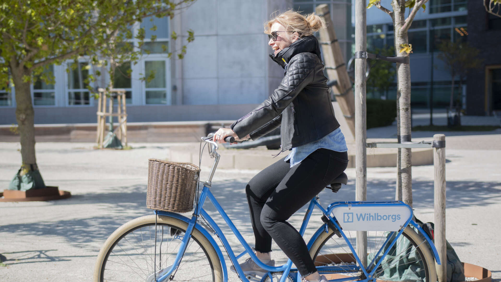 Kvinna som cyklar på en blå WIhlborgscykel.